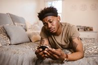 Man Lying on Bed while Looking at Picture Frame