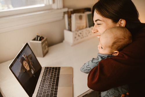 Free A happy mother and her baby making a video call on a laptop to connect with a loved one from home. Stock Photo