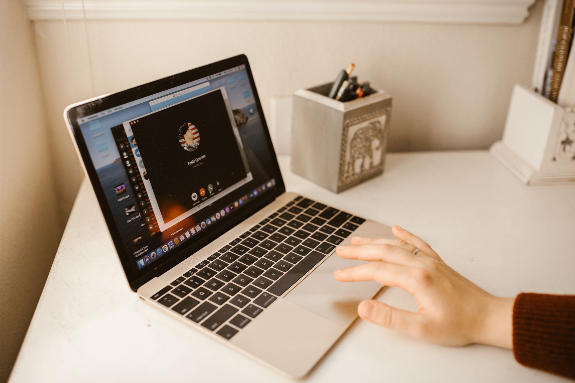 Pantalla de laptop con una videollamada de trabajo y una interfaz de software abierta al lado