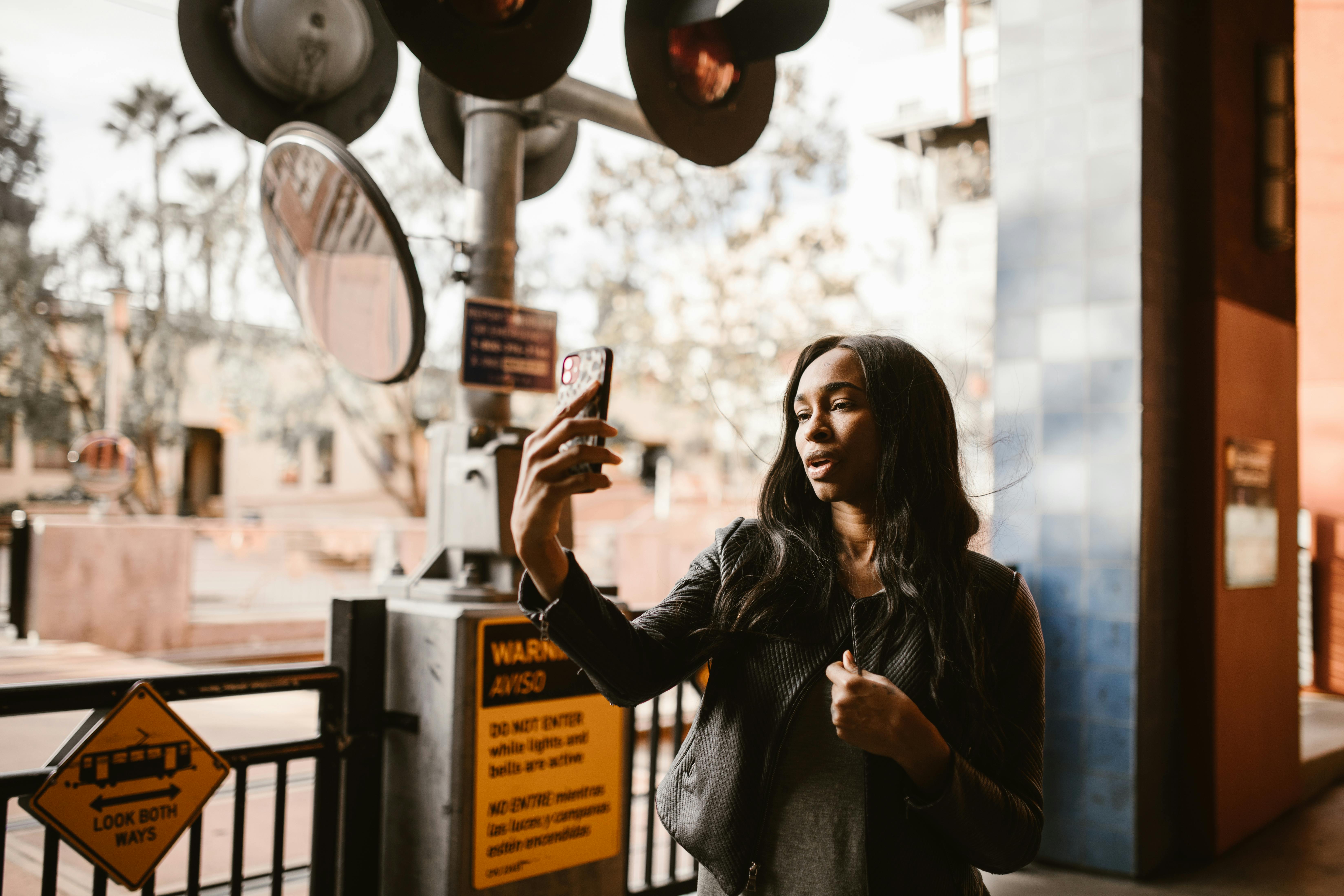 woman in black leather jacket holding smartphone