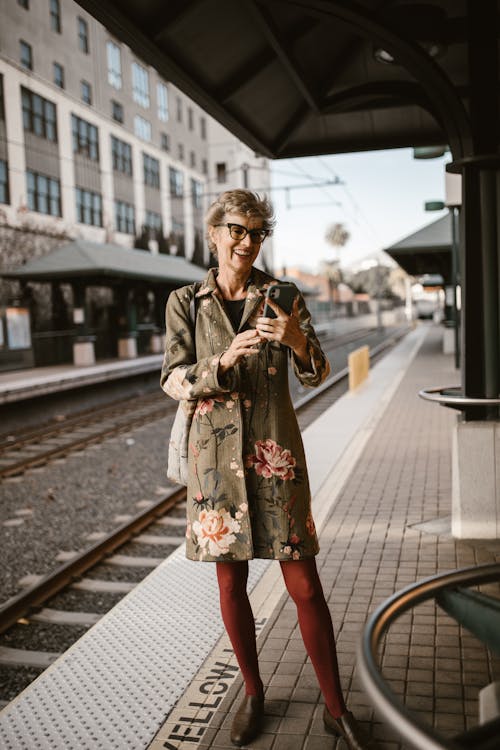 棕色和白色的花裙子，站在火車鐵軌上的女人