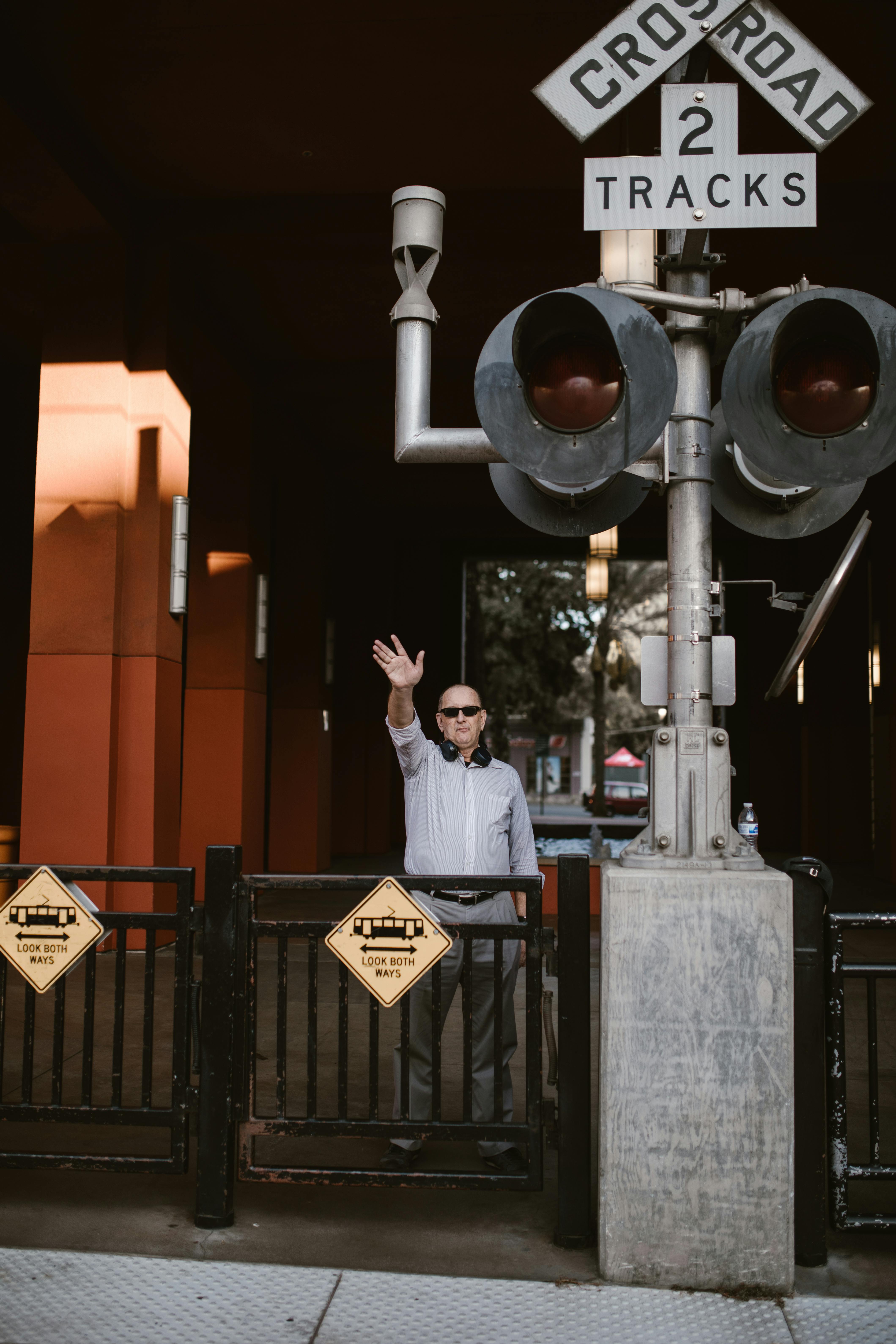 man in white dress shirt standing near traffic light