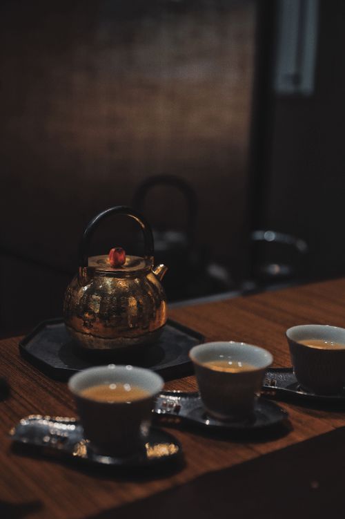 Free Moody still life of a ceramic cup and brass kettle on a wooden table. Stock Photo