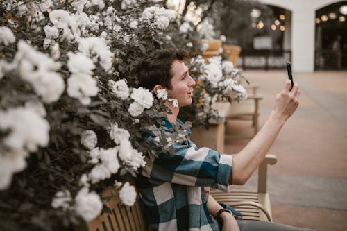 Ücretsiz adam, Ahşap bank, Beyaz çiçekler içeren Ücretsiz stok fotoğraf Stok Fotoğraflar