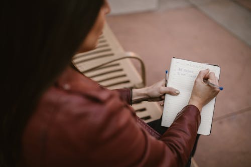 갈색 가죽 자켓, 공책, 사람의 무료 스톡 사진