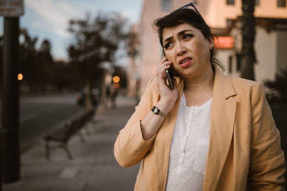 woman concerned phone sidewalk