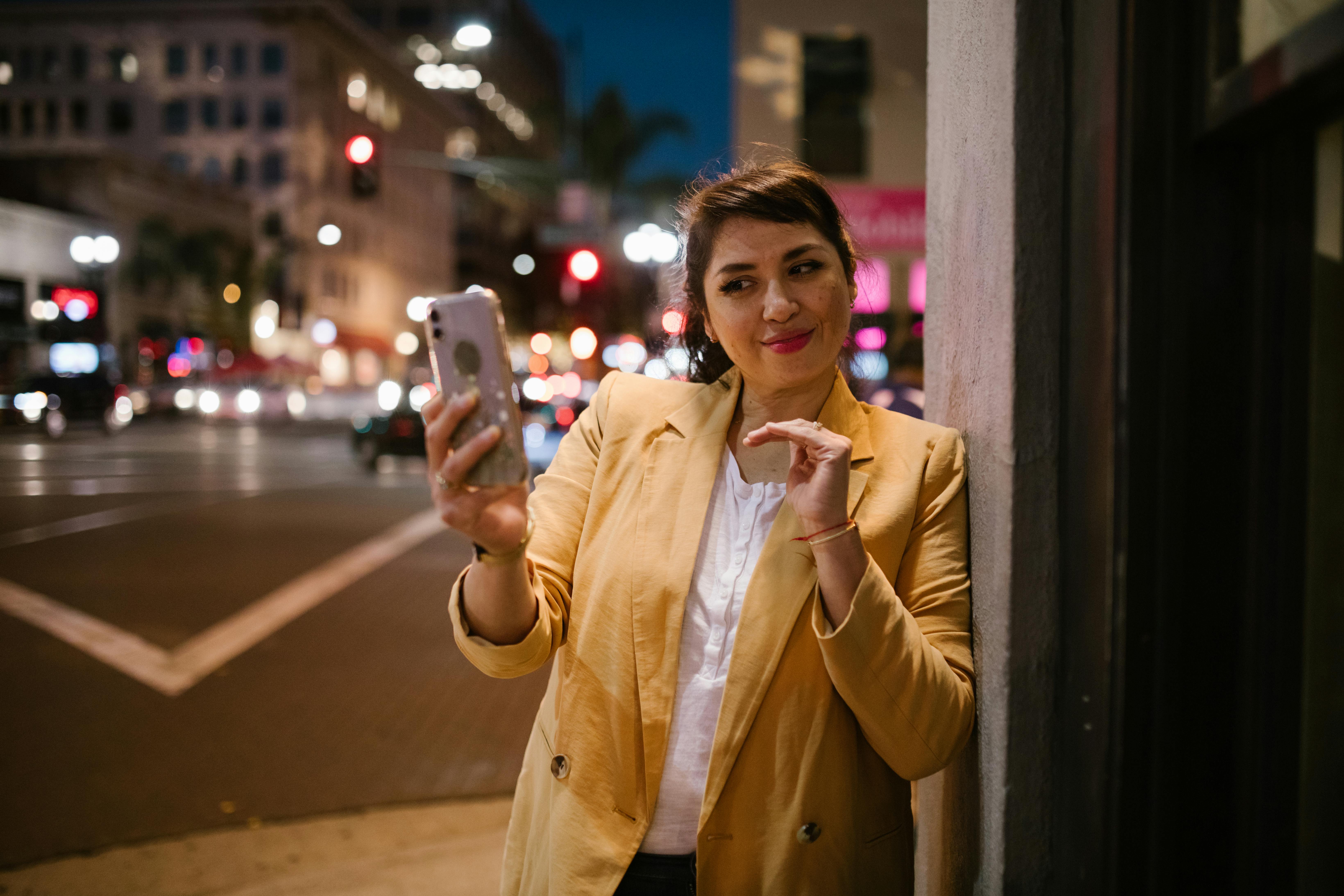 woman in brown coat holding iphone