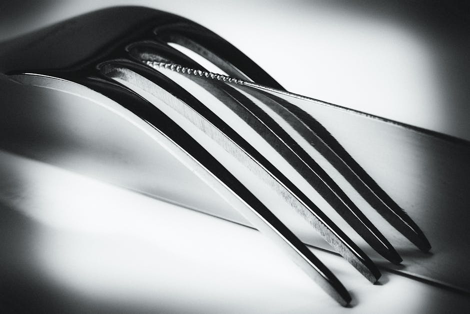 Silver Metal Fork on Top of a Silver Butter Knife