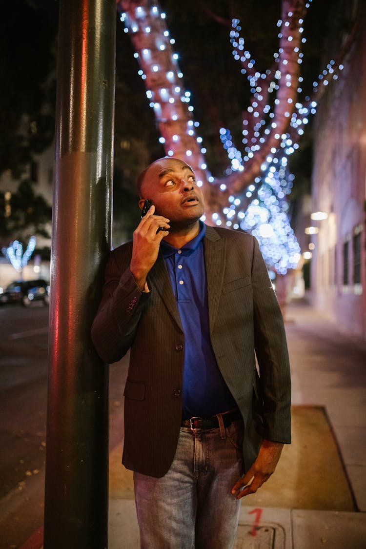 Elegant Man Talking On The Phone On A Street At Night