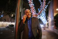 A Man in Black Suit Having a Phone Call