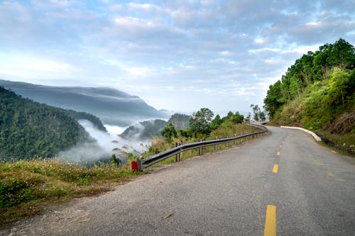 Asphalt road between green hilly terrain