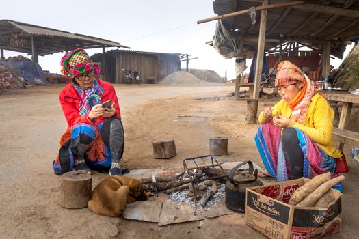 Asian women in traditional clothes cooking in village