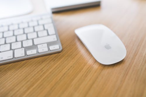 Free White Apple mouse and keyboard on a wooden desk Stock Photo