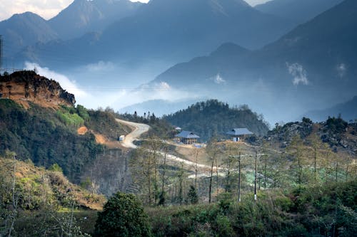 Scenic view of small settlement and curvy road going through lush valley in mountainous valley