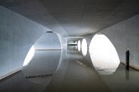 Area under arched concrete bridge situated and reflecting on rippling river surface in daylight