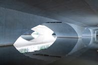 Area under white arched bridge reflecting in rippling calm river on sunny day