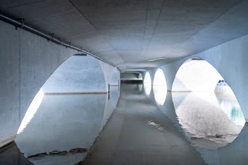 White arched bridge reflecting in rippling river