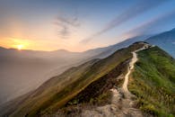 Distant person standing on hilltop in majestic highlands in twilight
