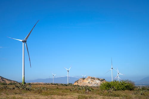 Free Wind turbines on highland under blue sky Stock Photo