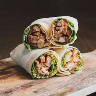 Charcoal chicken wraps stacked on a wooden board, photo by rajdeepcraft on Pexels