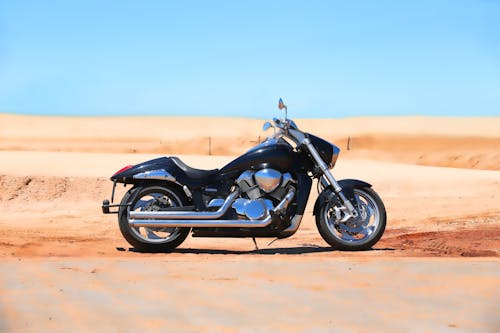 Free A Black Cruiser Motorcycle Parked in the Desert Stock Photo