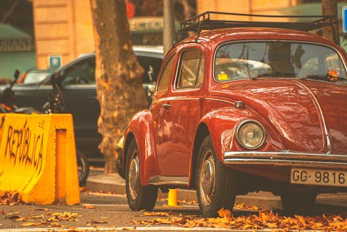 Free A Red Vintage Car Parked on the Road Stock Photo