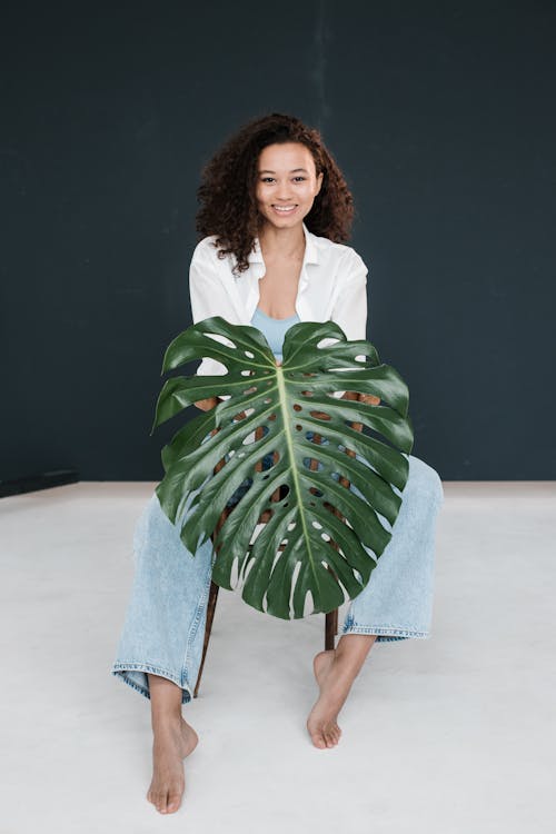 Photo Of Woman Holding Monstera Leaf