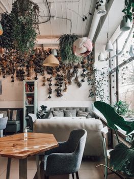 A beautifully designed cafe interior with lush plants and modern decor elements.
