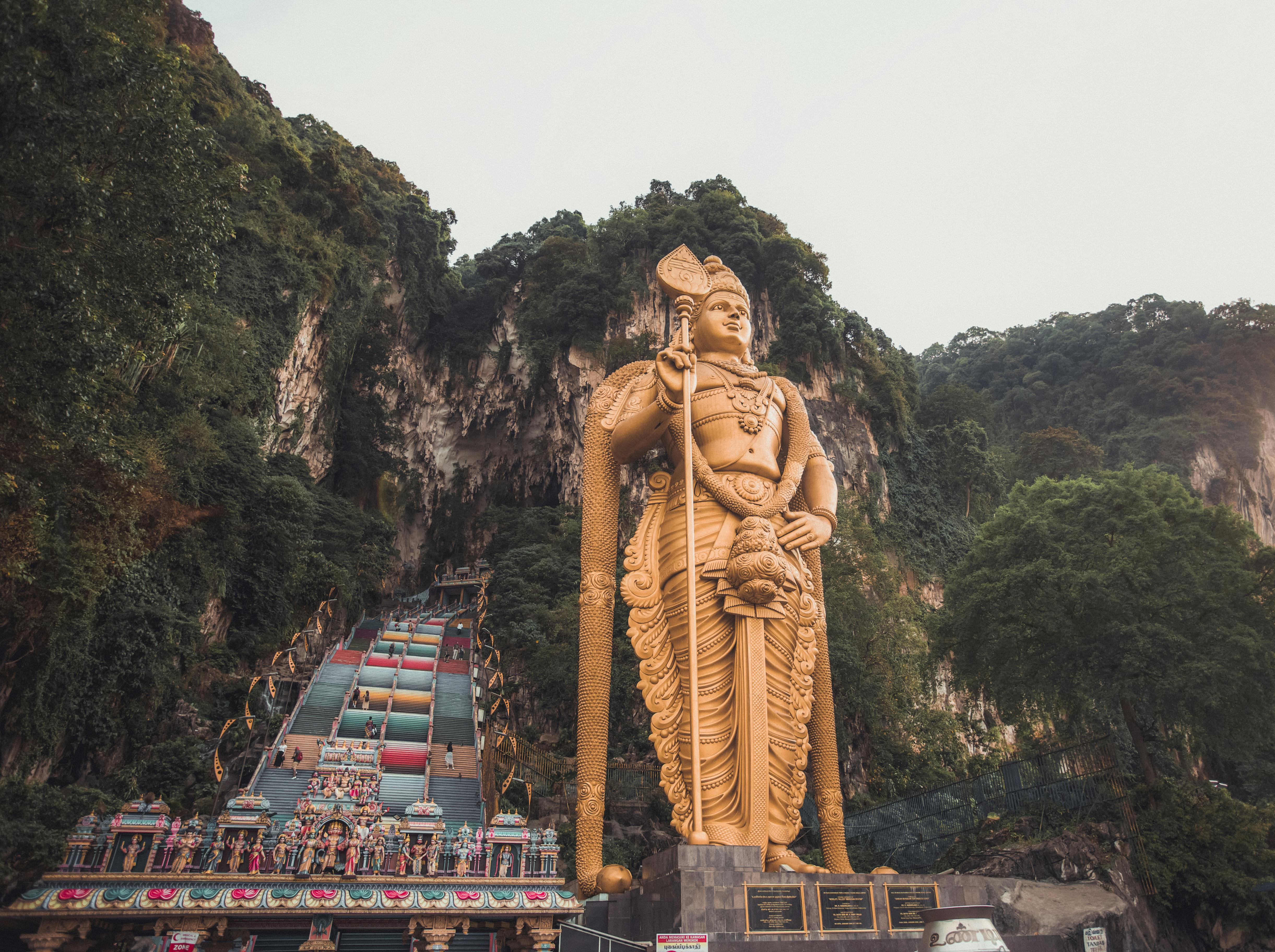 gold statue near green mountain