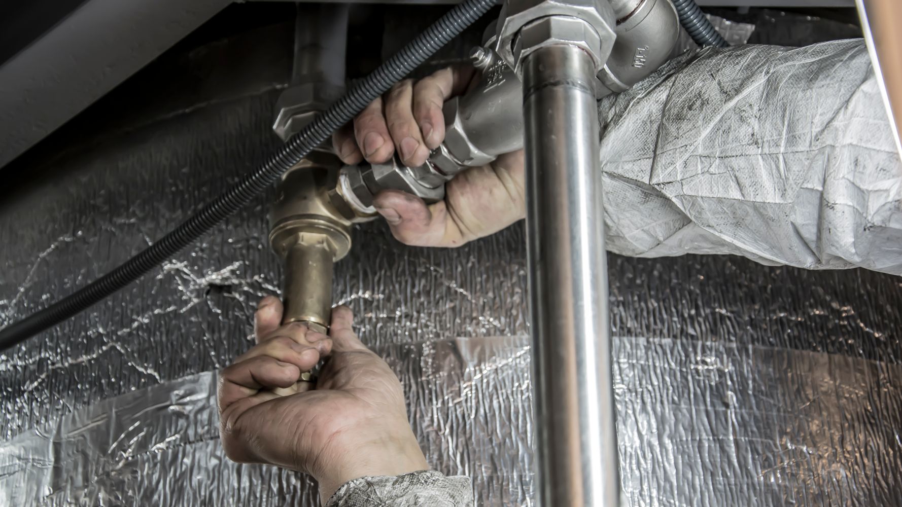 Commercial plumber installing steel pipework during maintenance in Dubai