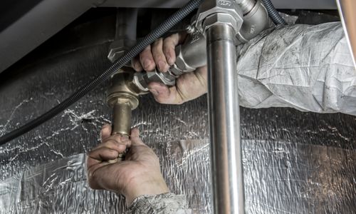 Plumber's hands installing steel pipe fittings