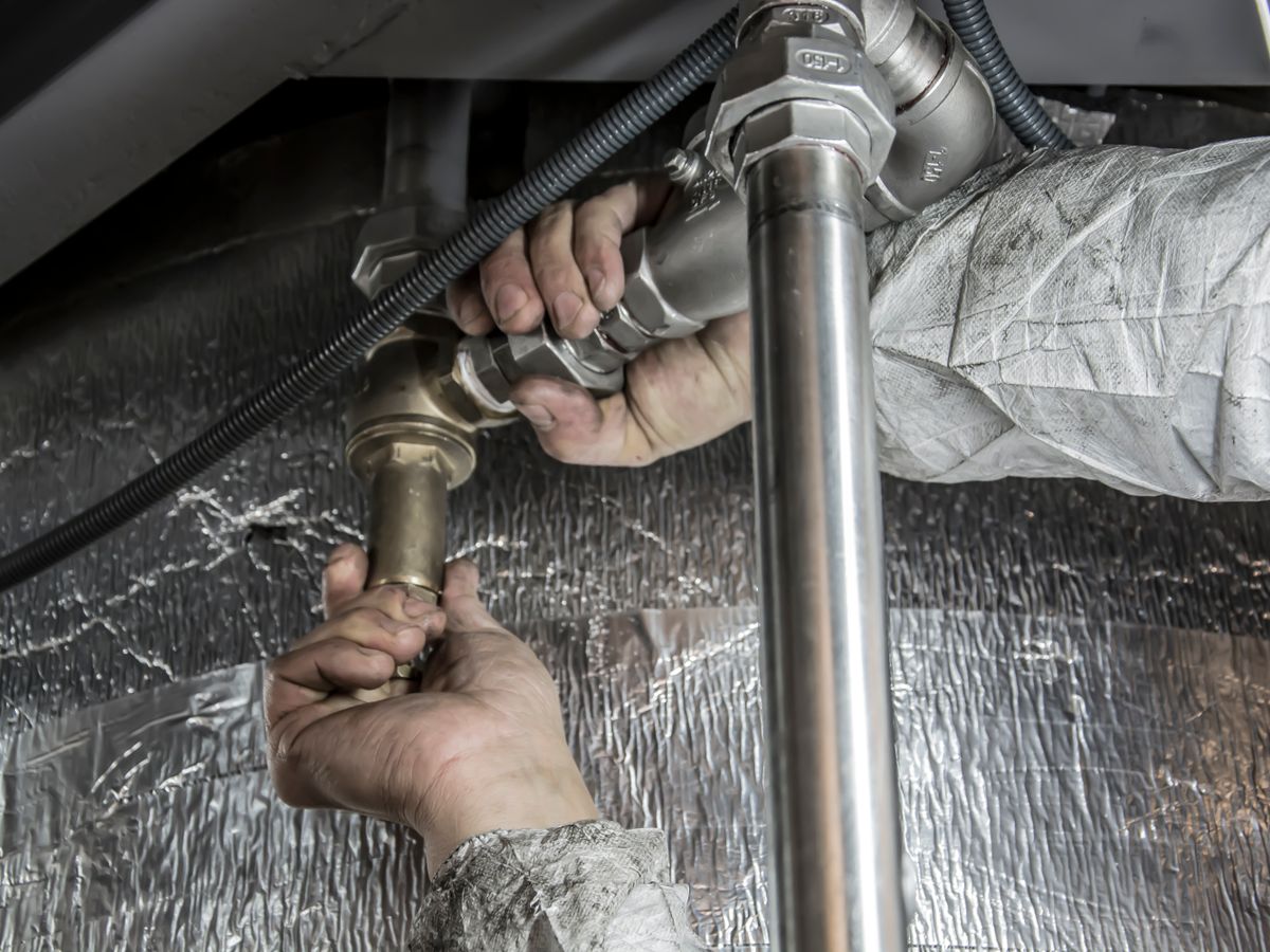 A plumber fitting pipework during a repair