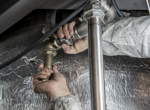Hands fitting new steel water pipes indoors
