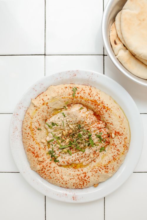 Free Creamy hummus drizzled with olive oil, served with fluffy pita bread. Stock Photo