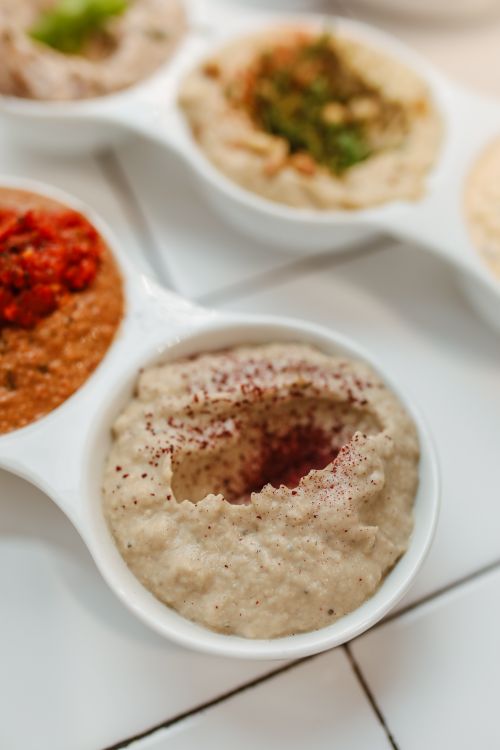 Free Close-up of various Middle Eastern dips in white dishes, highlighting textures and colors. Stock Photo