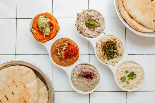 Free Delicious Mediterranean dips served with warm pita bread. Perfect for a savory meal or snack. Stock Photo