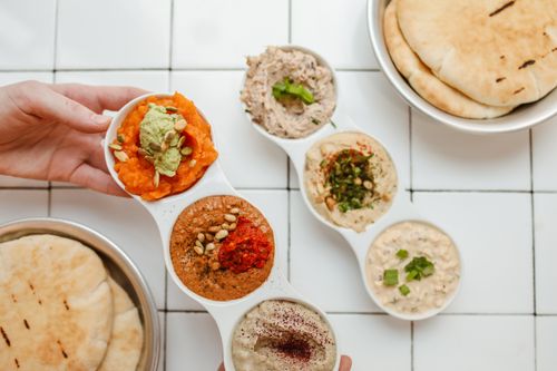 Free Assorted Mediterranean dips served with fresh flatbread. Perfect for group gatherings. Stock Photo