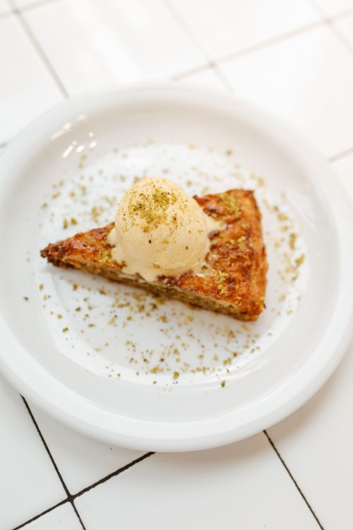 Free Delicious slice of baklava topped with ice cream, perfect for dessert lovers. Stock Photo