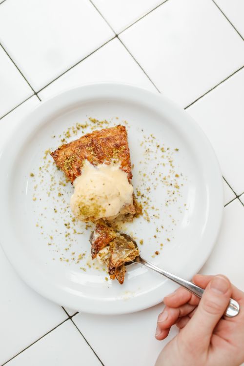 Free Overhead view of honey cake slice topped with ice cream on a white plate. Stock Photo