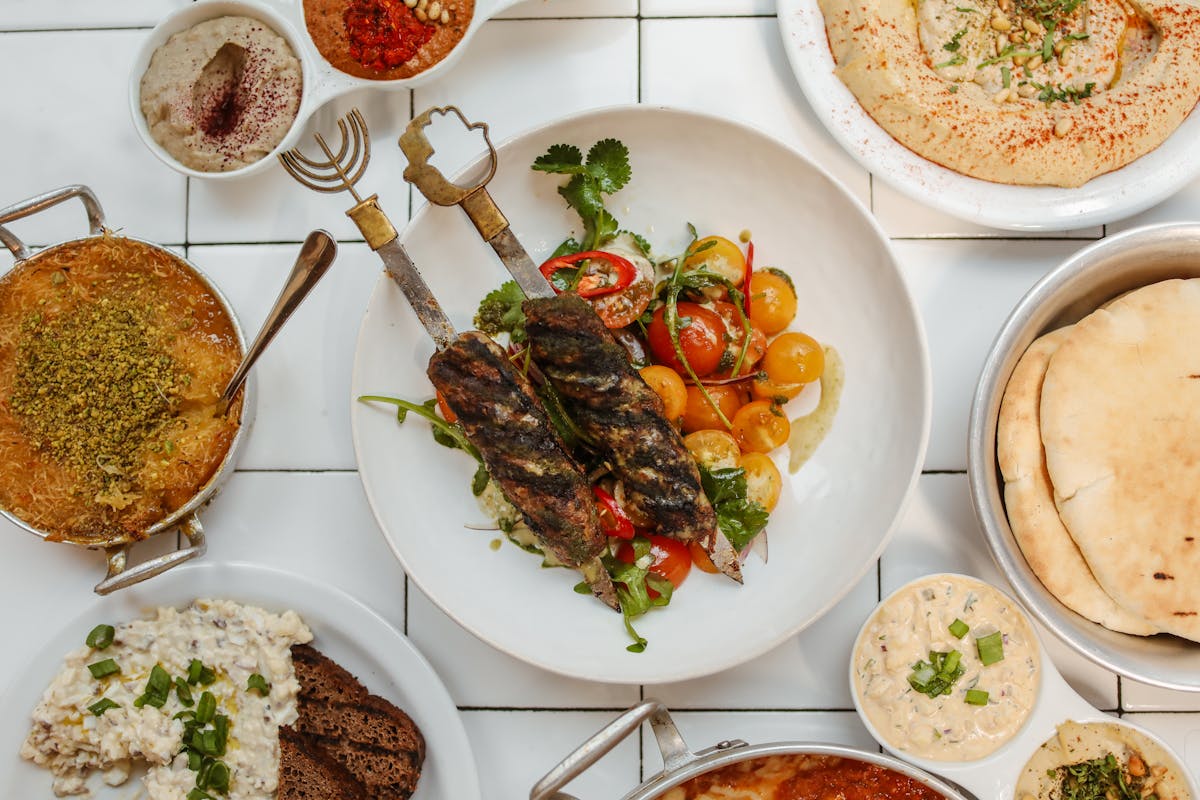 Pita, hummus, varie salse e verdure disposte su un tavolo
