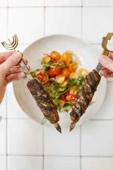 Delicious grilled lamb kebabs served with a fresh vegetable salad, perfect for a traditional festive meal.