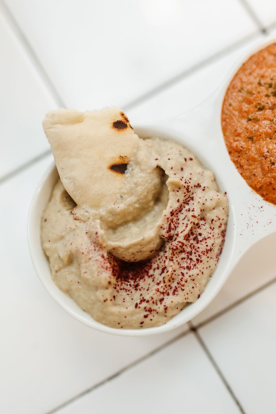 Pita bread dipping into hummus