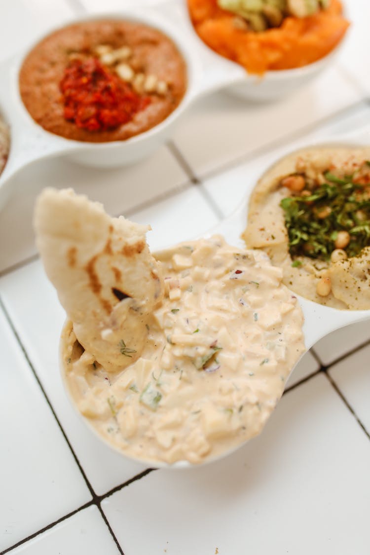 Dipping Pita Bread In Hummus Paste