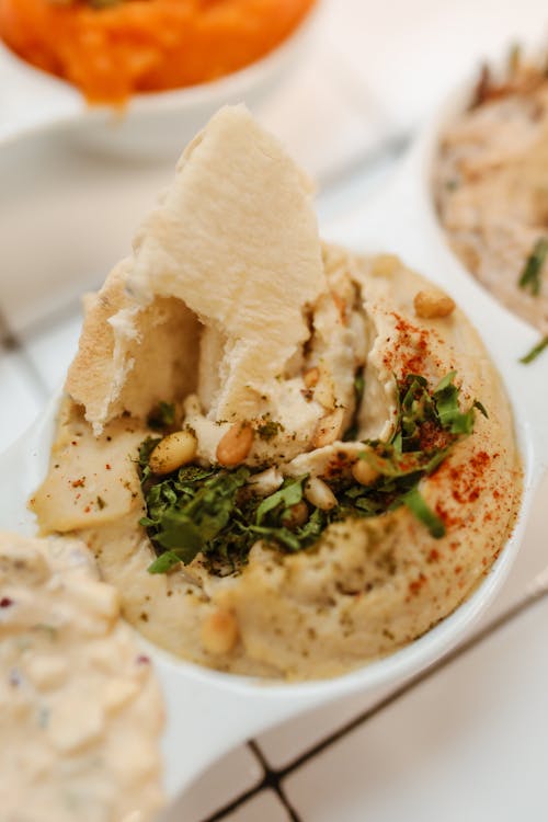 Free Dipping Pita Bread in Jewish Hummus Paste  Stock Photo