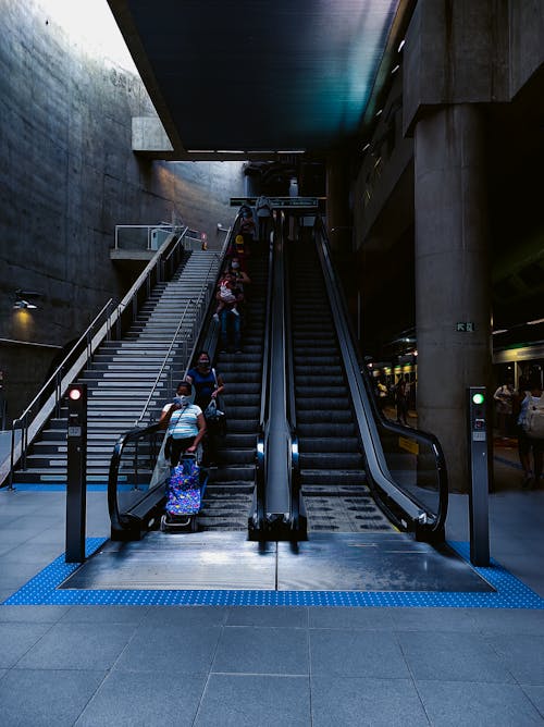 Anonymous passengers standing on moving escalator in underground metro station