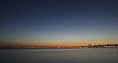 黄昏时分，城市景观宁静，星光熠熠，大海平静，营造出宁静的夜晚氛围