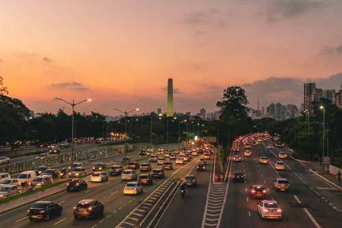 Free Aerial view of city traffic on expressway at sunset, capturing urban life and cityscape. Stock Photo