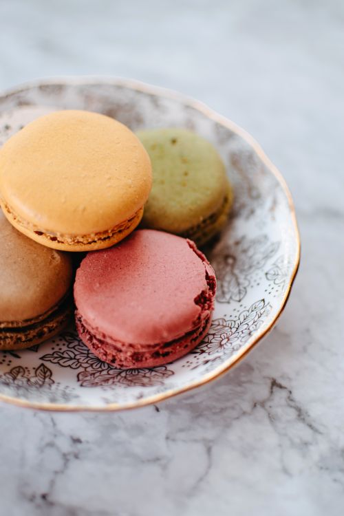 Free Beautiful close-up of colorful macarons on a decorative porcelain plate on a marble surface. Stock Photo