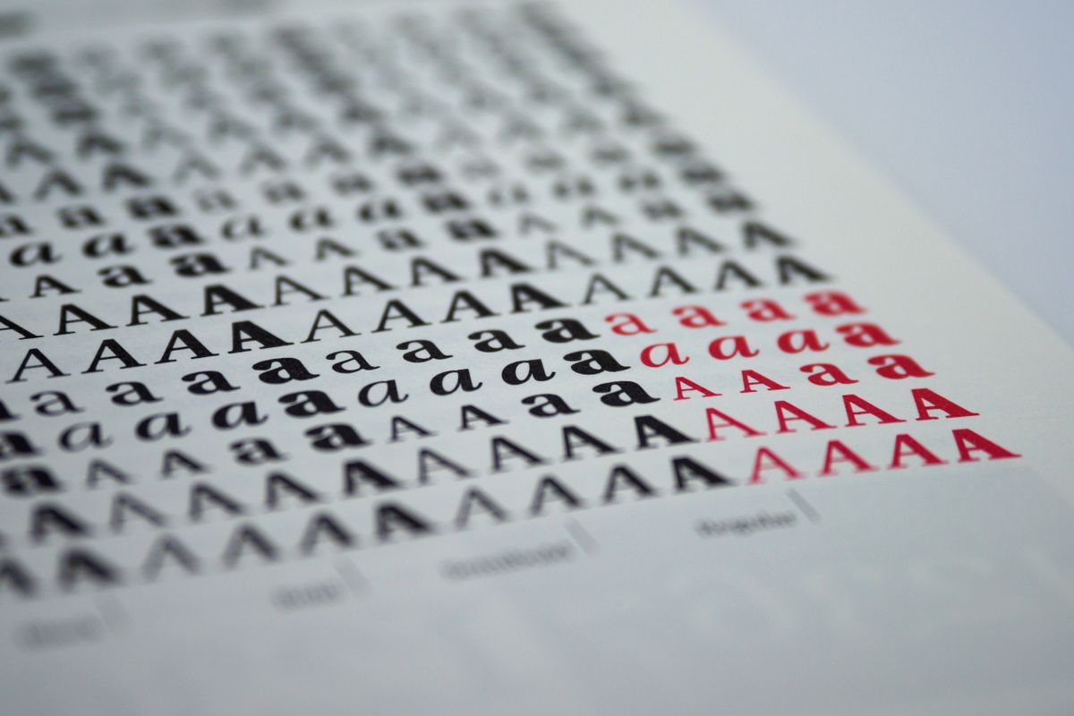 Rows of the printed letter A in many different typefaces, in black and red, on white paper