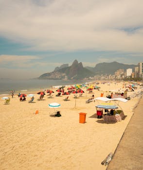Stunning view of Ipanema Beach in Rio de Janeiro with colorful umbrellas and mountains in the background.
